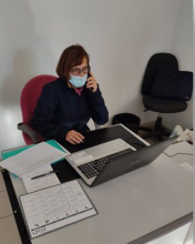 image d'une femme au téléphone devant son ordinateur et communiqué à la fois au téléphone sur le site epicerie-sociale-solidaire-lapasserelle